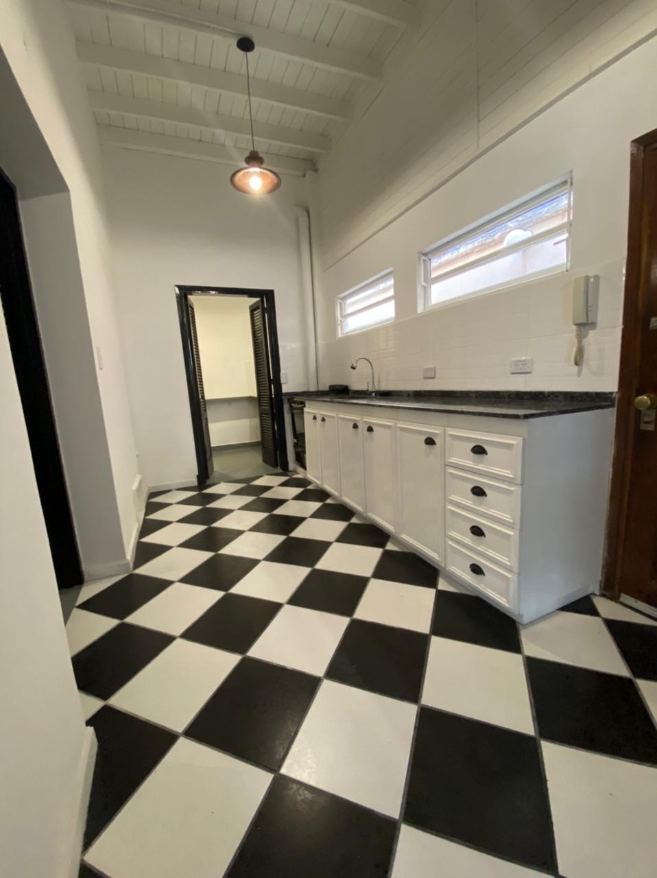 Cocina con mueble de cocina a mediad y piso damero.