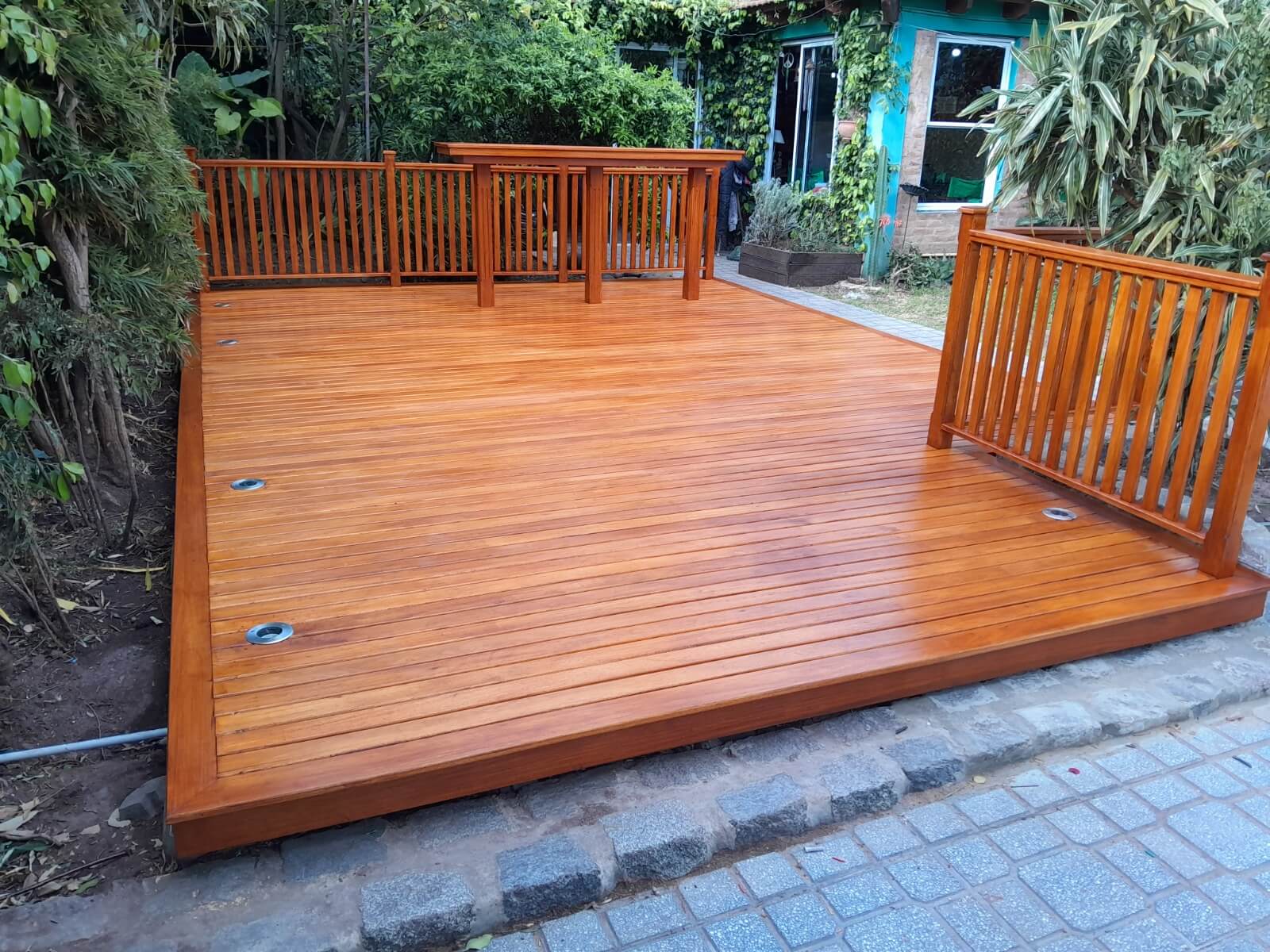 Deck de madera en jardin, con barra integrada.