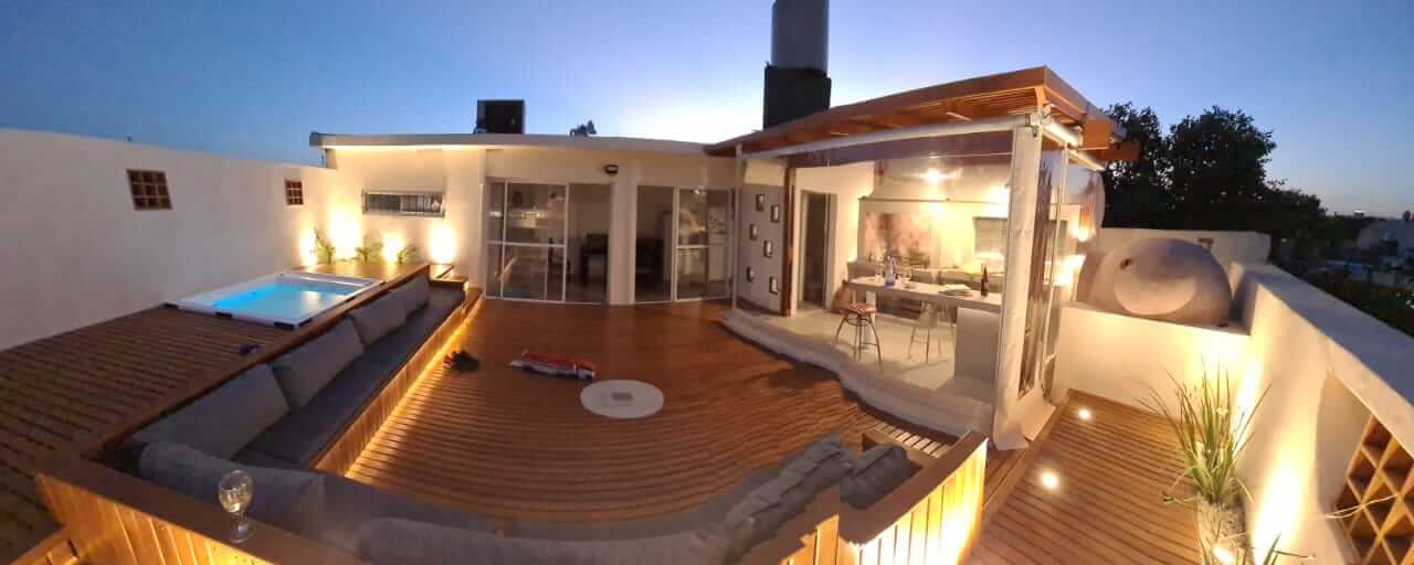 Deck de madera con parrilla y pergola.