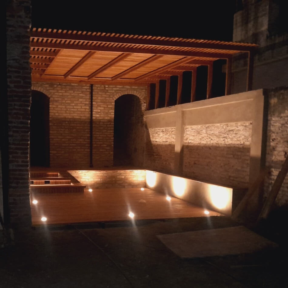 Deck y pergola de madera con iluminacion nocturna.
