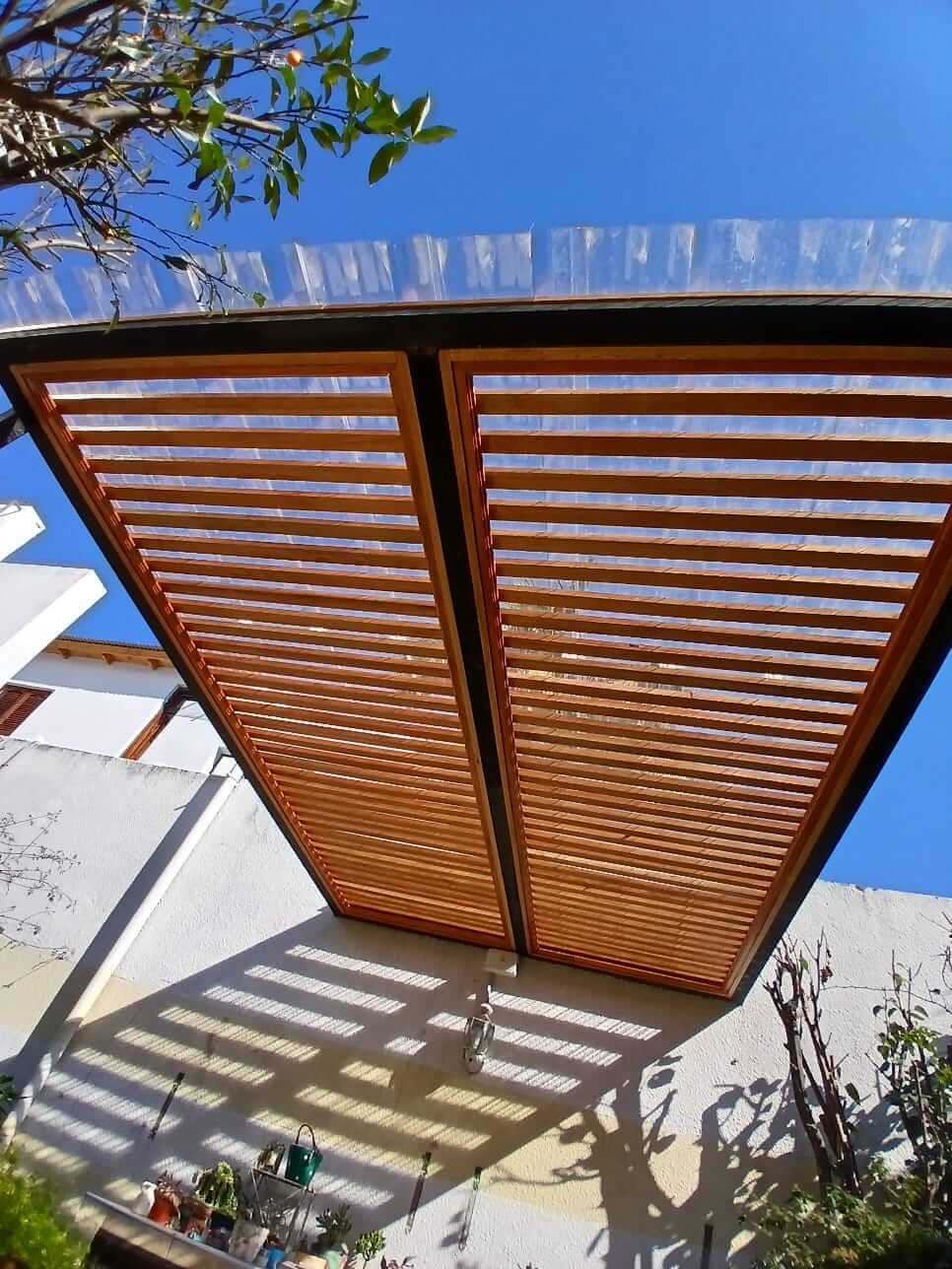 Pergola de madera en jardin.